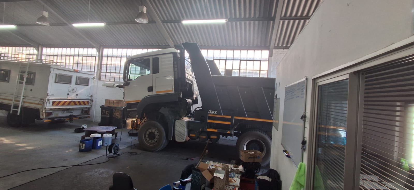 Tipper truck raised in the DTL Mechanical Repairs workshop bay during a repair